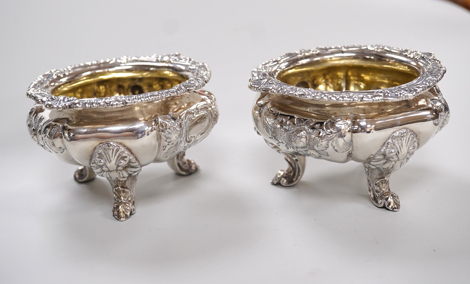 A pair of early Victorian silver cauldron salts, by John Tapley, London, 1838, with later blue glass liners, diameter 94mm, together with a pair of George IV silver Old English pattern condiment spoons, London, 1828.